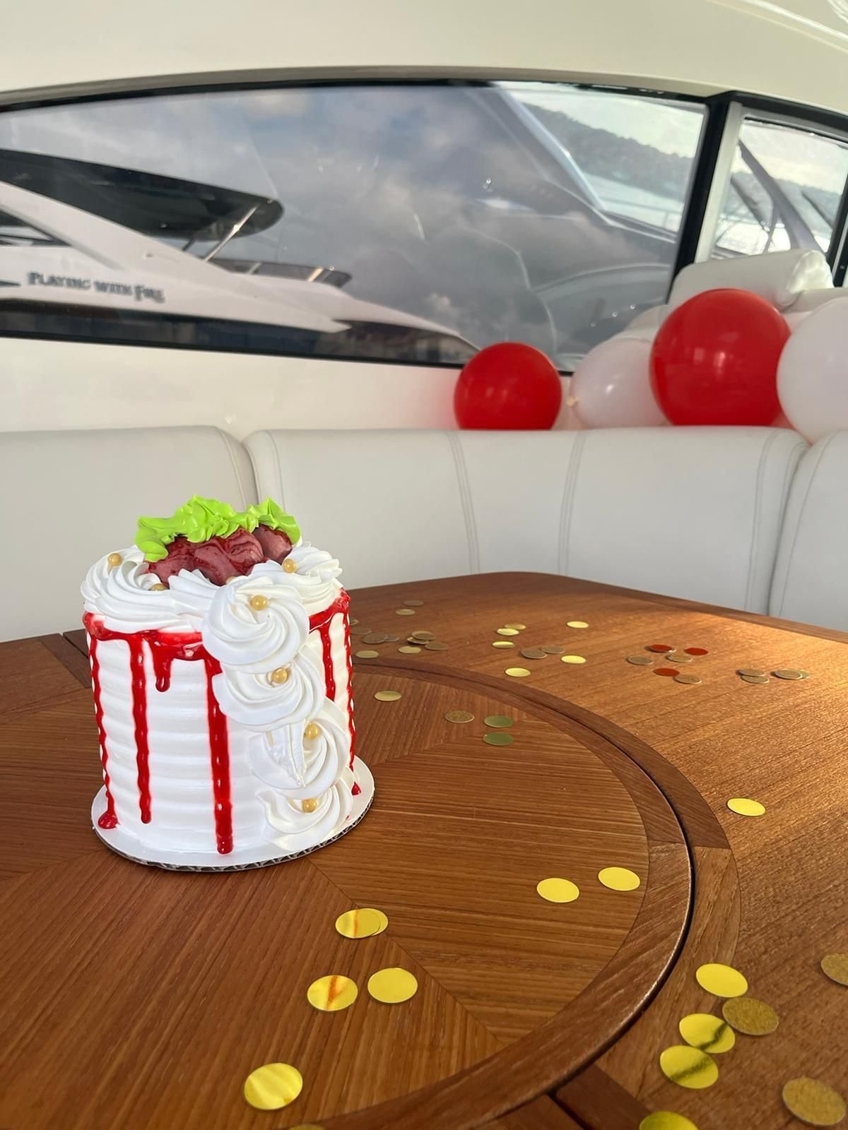 Birthday cake set up on a private yacht in Puerto Rico with balloon decorations in the background