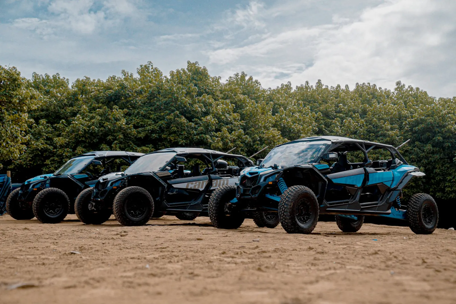 Fleet of Can-Am Maverick X3 MAX 4-seat off-road vehicles lined up on a sand trail in Puerto Rico