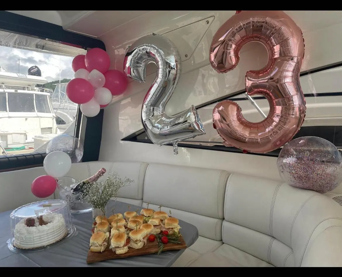 Number balloons cake and food spread onboard yacht