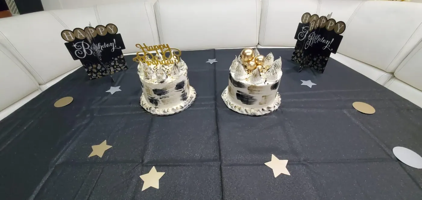 Two birthday cakes with Happy Birthday signs onboard yacht