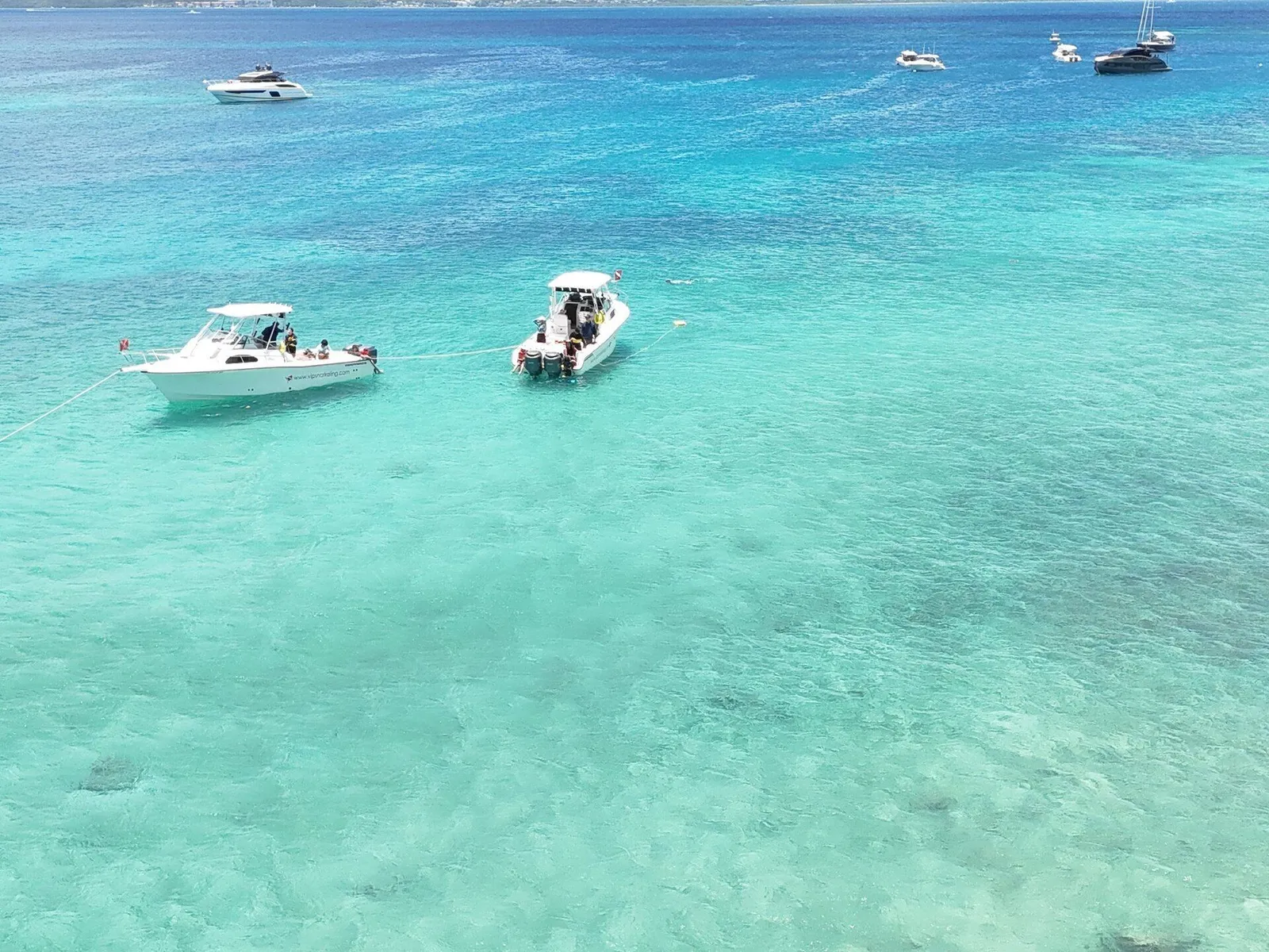 Aerial of two charter boats in crystal-clear turquoise Caribbean water