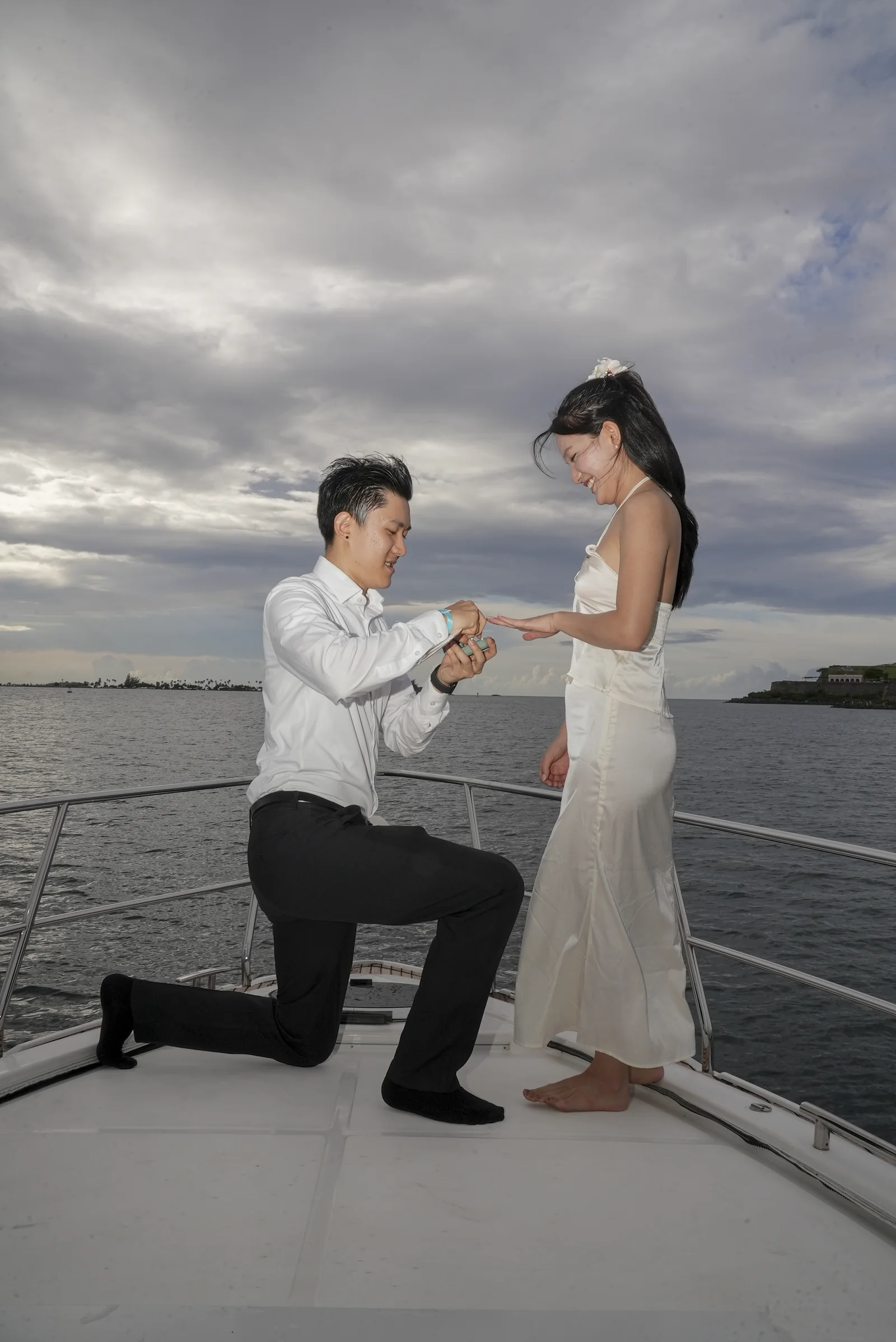 Real proposal moment on a Boating Puerto Rico yacht charter in San Juan Bay — he kneels to present the ring