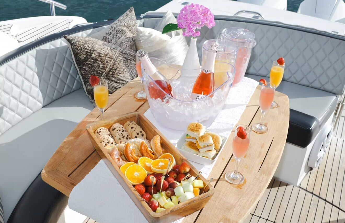 Styled champagne, mimosas, fresh fruit and charcuterie spread on the deck of the Schaefer 45 luxury sport yacht